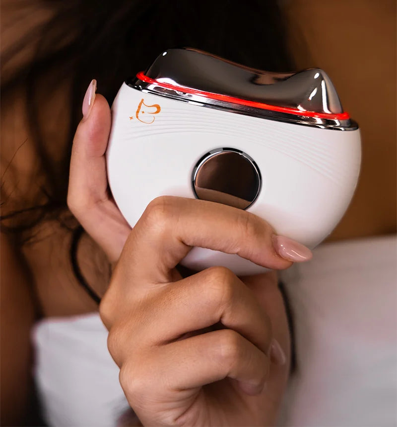 Hand holding GlowLift™ Infinity with its red warm-mode light on