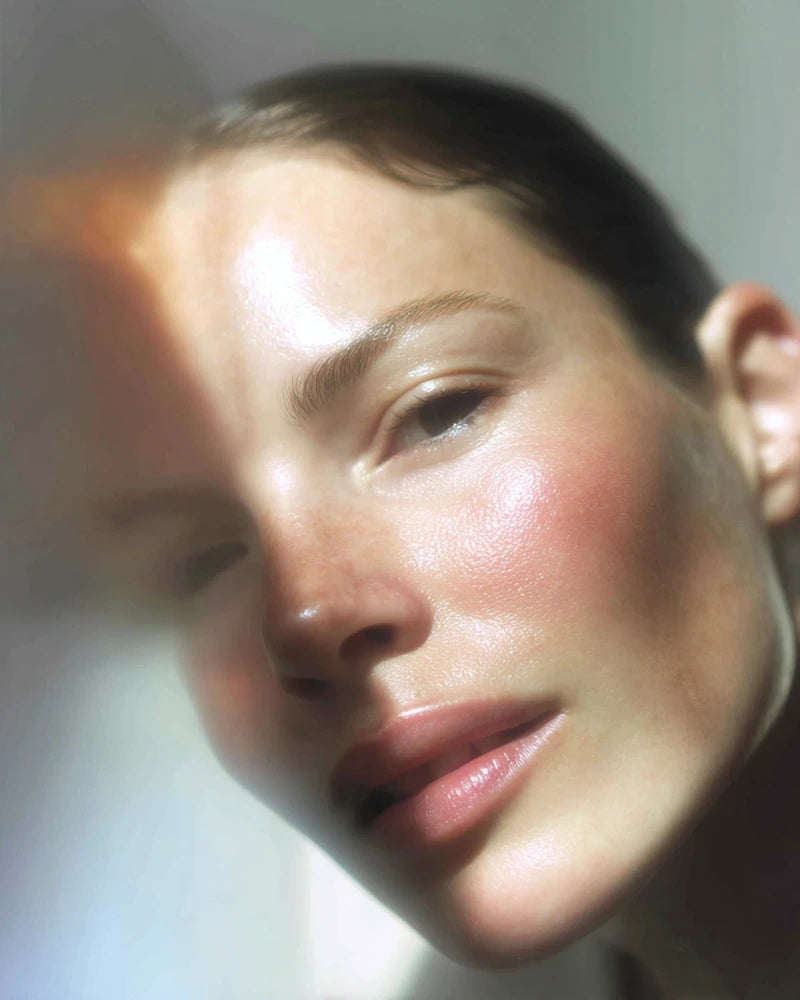 Woman with dewy, radiant-looking skin in soft window light